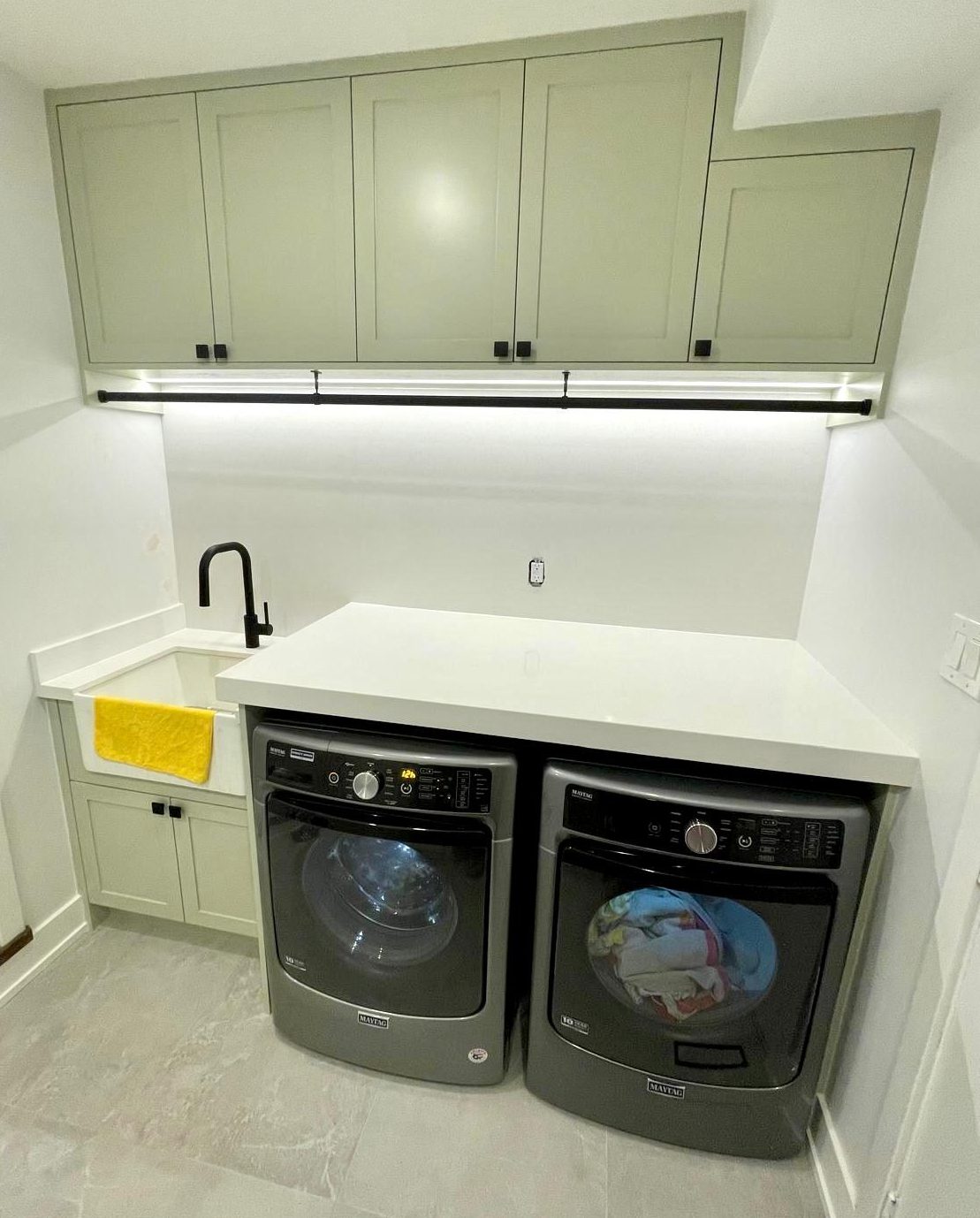 Mudroom bench with built-in shelving and vertical slat wall next to the laundry area