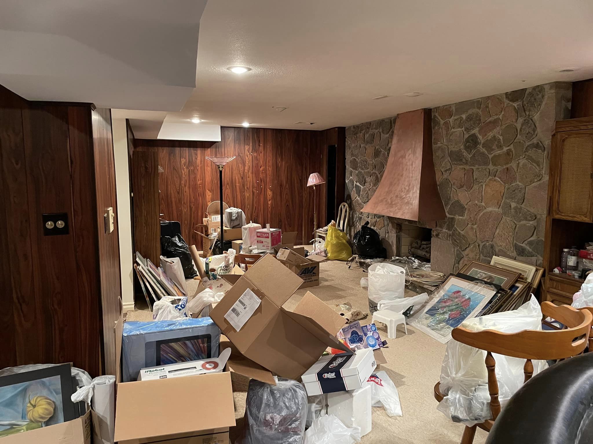 Basement fireplace before renovation, cluttered with moving boxes