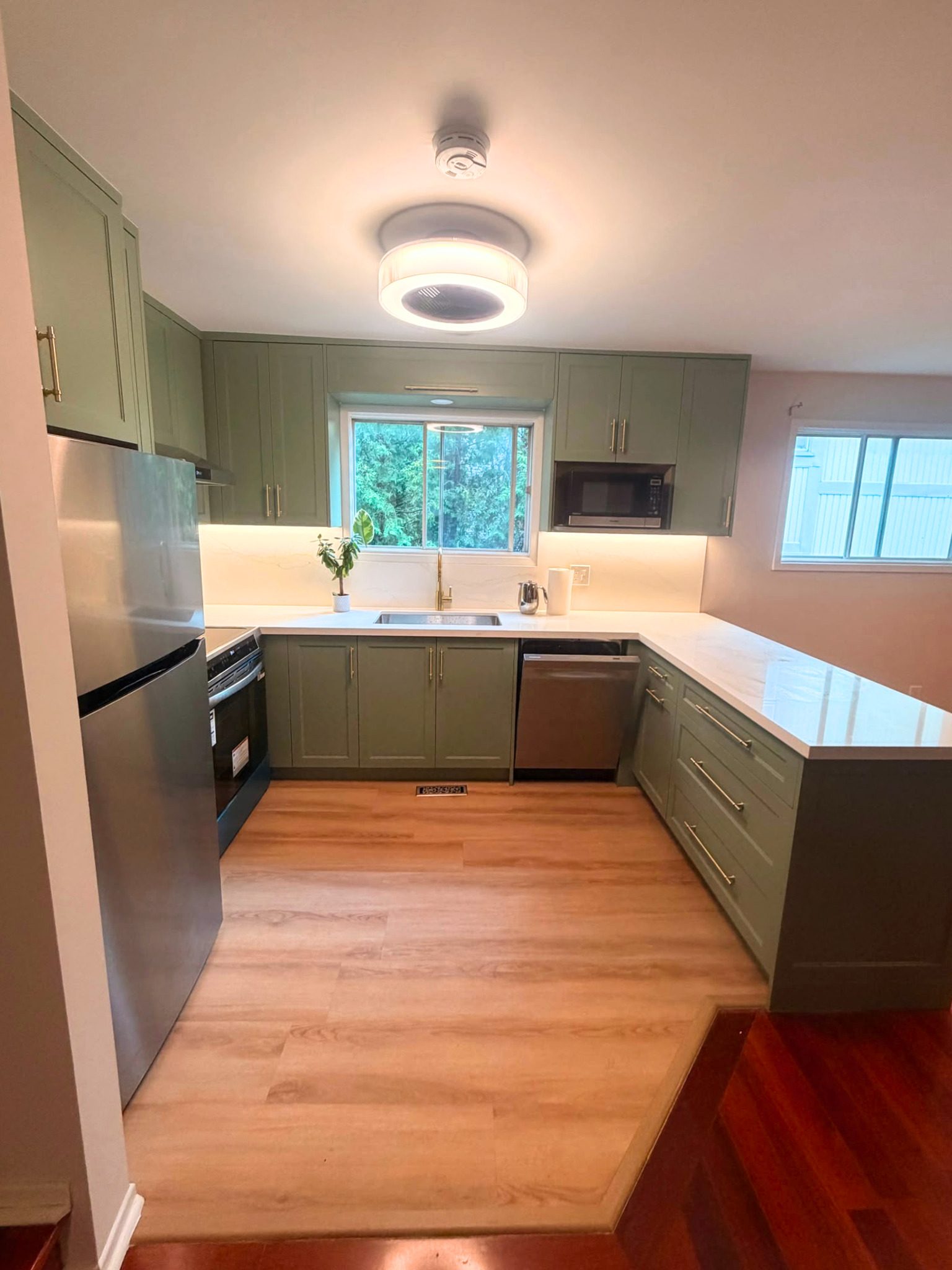 North York kitchen after renovation with sage green cabinets and gold hardware